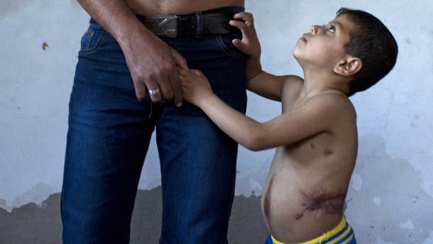 Third Place: Heidi Levine's photograph shows a disabled veteran with his five year old son. 37732828