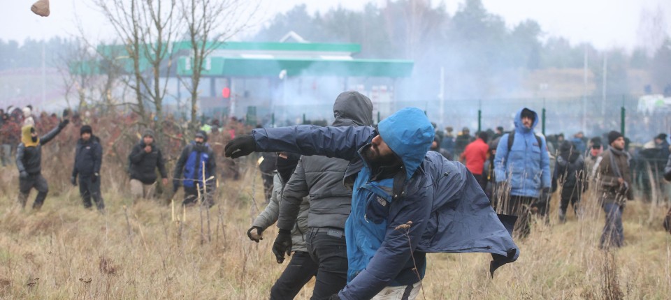 Migranten werden Steine in Richtung der polnischen Sicherheitskräfte.