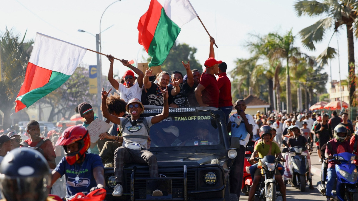 Ein Pickup-Truck fährt am Dienstag durch Antananarivo, Madagascar. Die Insassen schwenken Fahnen, nachdem sich das Militär den Demonstranten angeschlossen hat. - Reuters