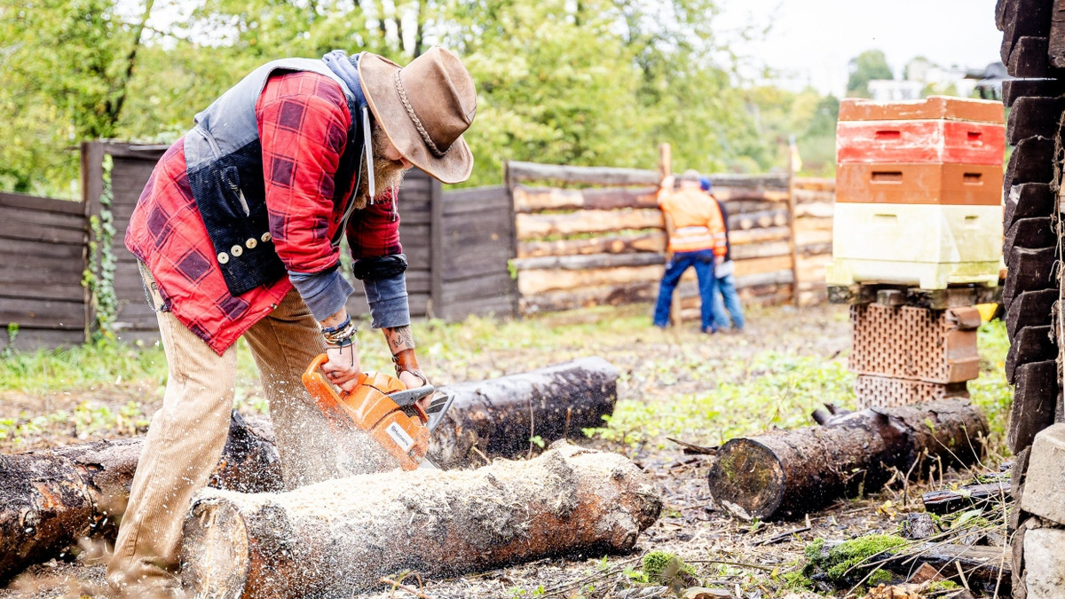 Ein Mitglied der Hammer Ranch sägt Holz, um einen Zaun zu flicken. Alle engagieren sich hier ehrenamtlich. Der Cowboyhut darf nicht fehlen. - Michael Braunschädel