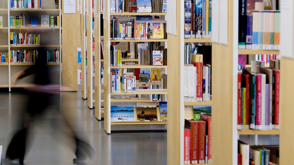 In Leipzig geht eine Mitarbeiterin der Stadtbibliothek an Bücherregalen vorbei. - Sebastian Willnow/dpa