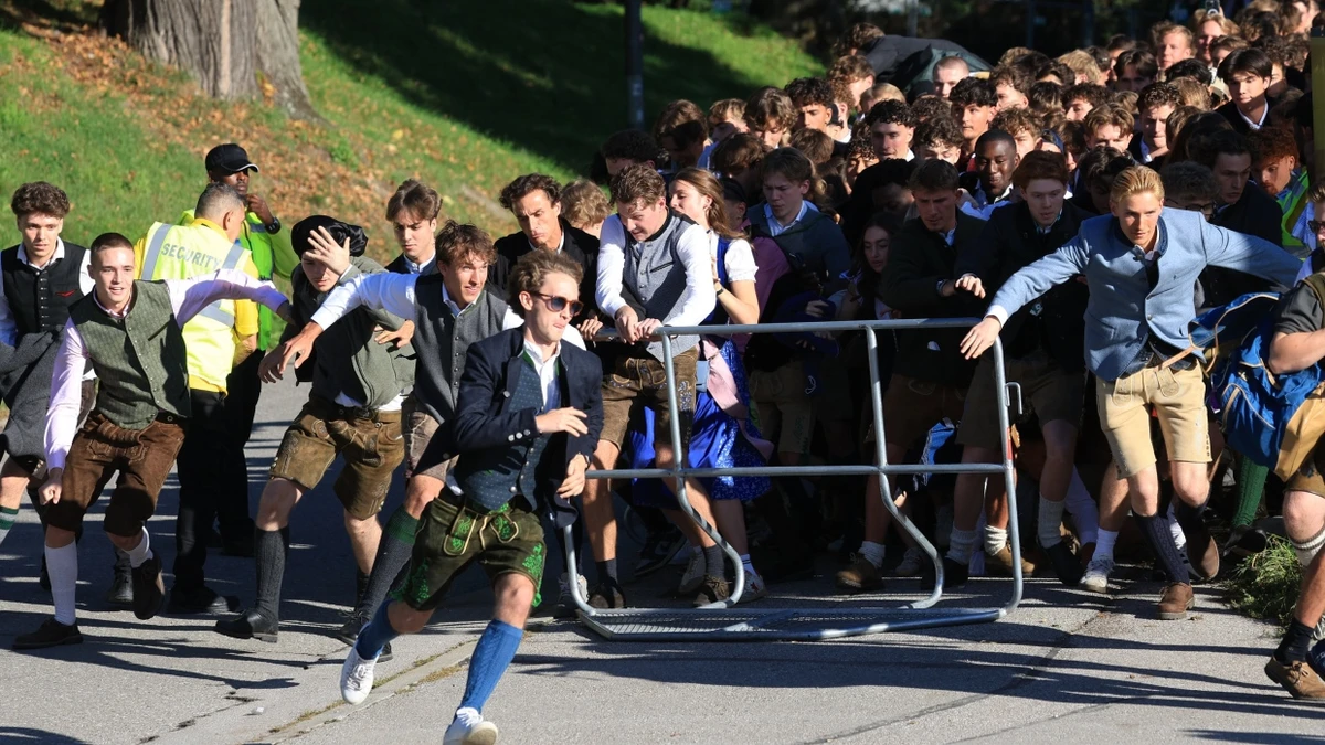 Sie alle wollen einen Platz im Zelt: Besucher stürmen zum Start des Oktoberfestes auf die Festwiese. - dpa