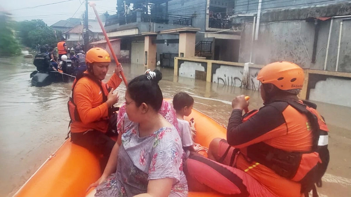 Ein von der Nationalen Such- und Rettungsbehörde Indonesiens veröffentlichtes Foto zeigt, wie Retter Bewohner mit Schlauchbooten aus ihrem überfluteten Haus holen. - dpa