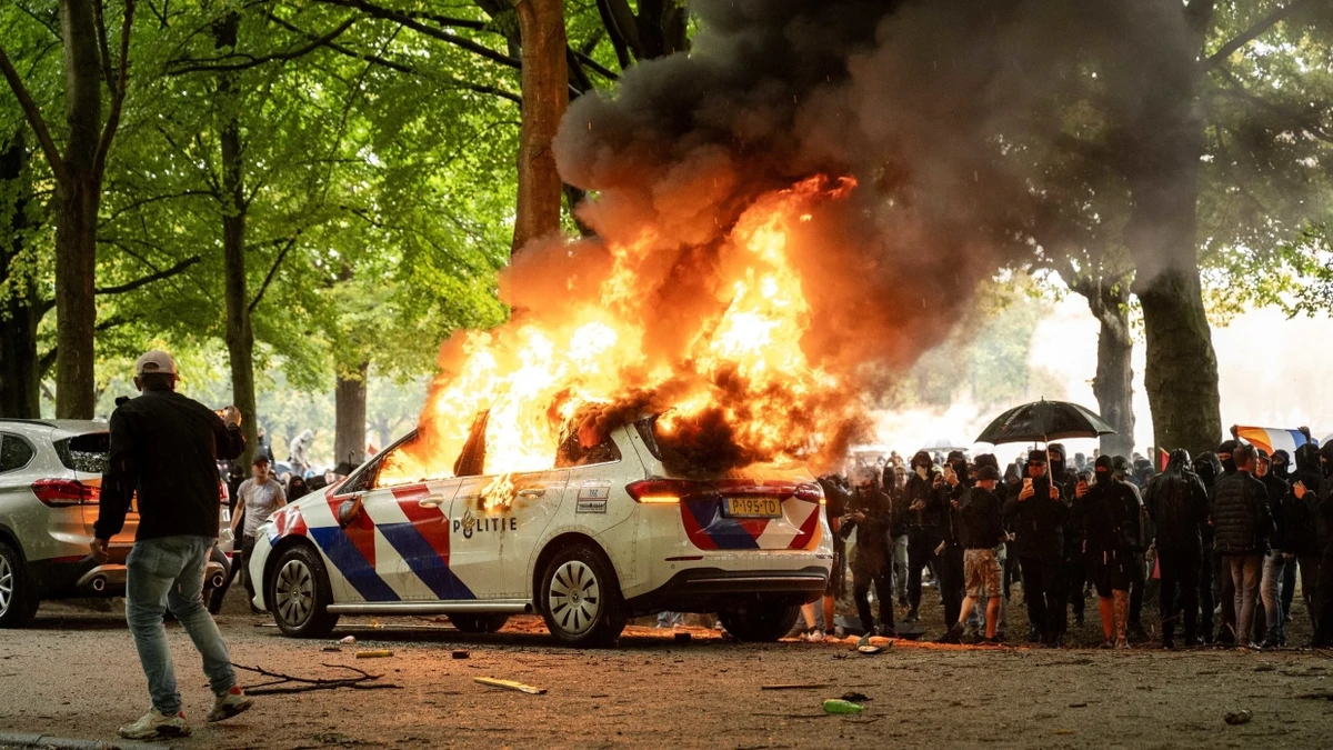 Bei einer Protestaktion gegen die aktuelle Asylpolitik auf dem Malieveld in Den Haag wurde ein Polizeiauto angezündet. - dpa