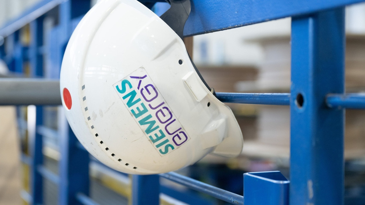 Ein Schutzhelm mit der Aufschrift „Siemens Energy“ hängt in einer Werkhalle im Transformatorenwerk in Dresden. Die Aktien des Unternehmens sind aktuell hinter Rheinmetall der zweitgrößte Gewinner im Dax. - dpa