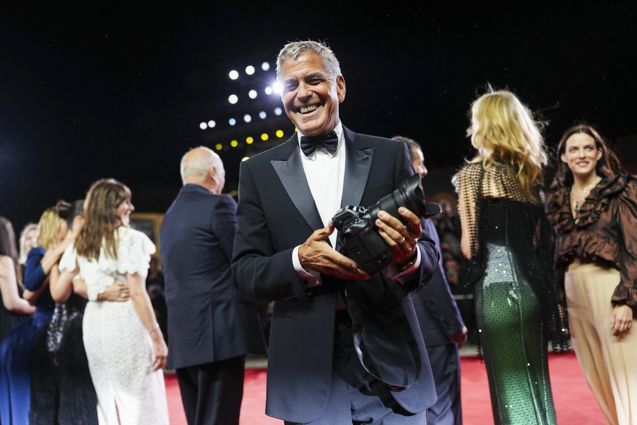 Am Ende ging es immer besser und er war zu Witzen aufgelegt: George Clooney hält die Kamera eines Fotografens bei der Ankunft für den Film