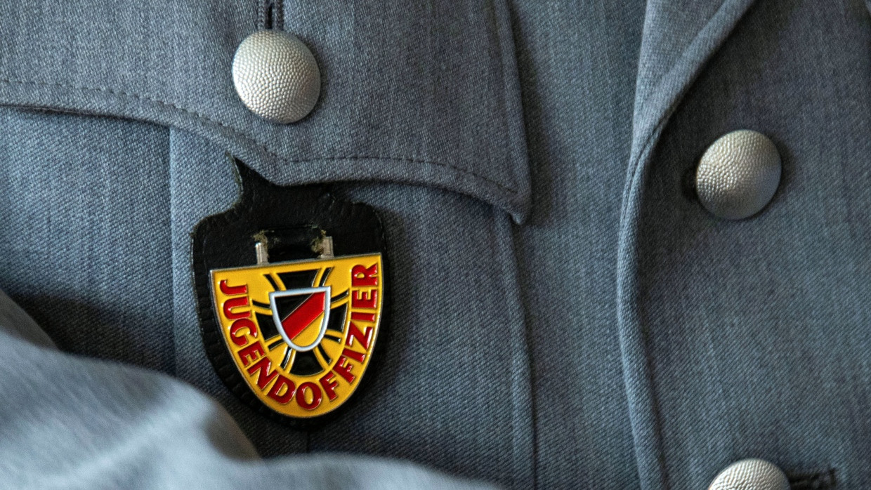 Ein Bundeswehrsoldat trägt ein Abzeichen mit der Aufschrift „Jugendoffizier“ an der Brusttasche.